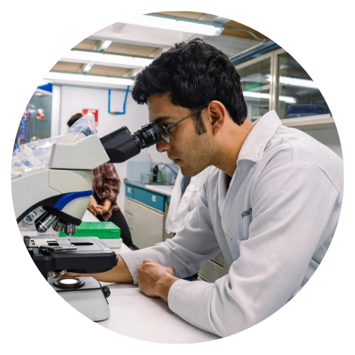 Scientist looking through microscope in a biotechnology laboratory