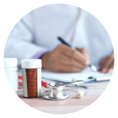 Researcher writing notes with medical equipment and medicine bottles