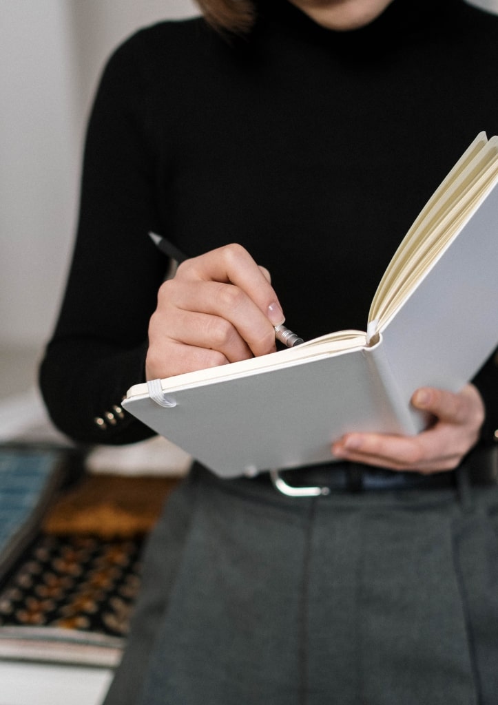 Person taking notes in open notebook