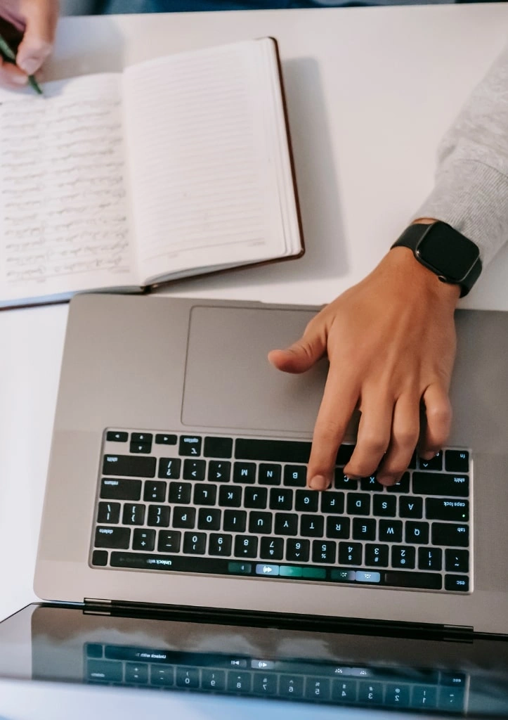 Researcher typing journal submission on laptop