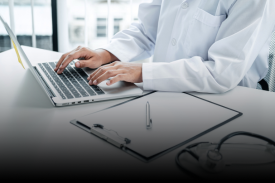 Healthcare professional reviewing medical data on laptop