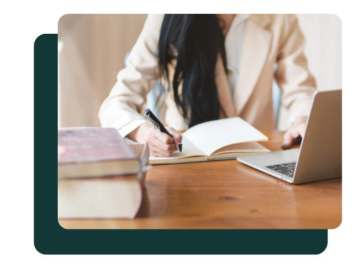 Researcher working on grant proposal draft with laptop and notebook